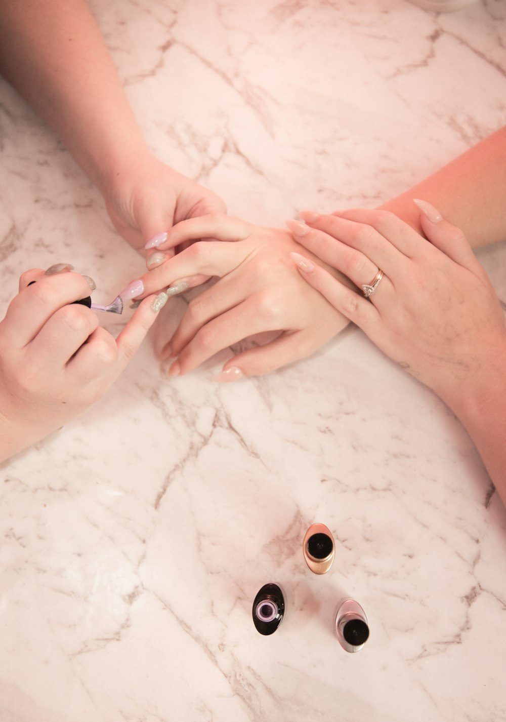 person holding silver ring on white textile