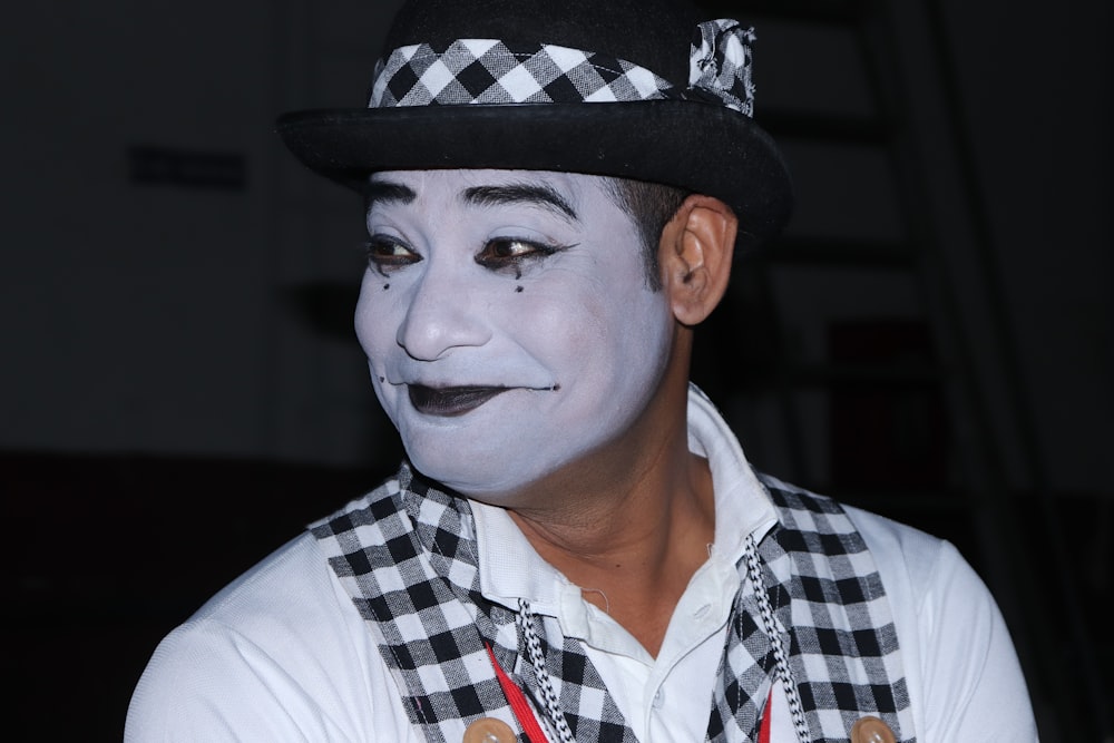 man in white button up shirt wearing black and white checkered hat