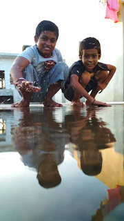 An intimate shot of children playing near the water’s edge, their laughter captured against the backdrop of ancient steps.