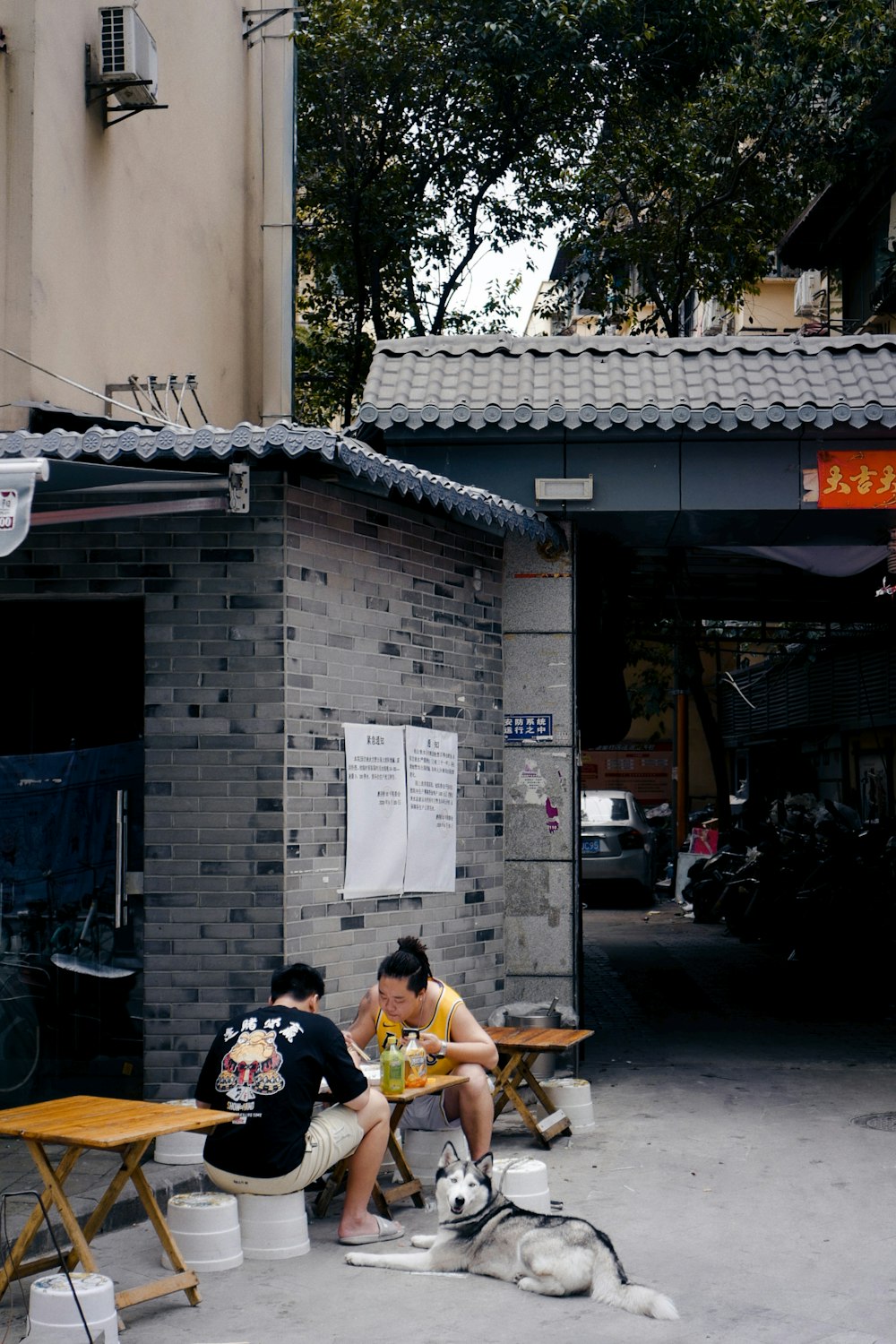 man in yellow shirt sitting on chair near motorcycle during daytime