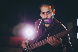 Jaco Pastorius passionately playing his fretless bass on stage, spotlight highlighting his intensity