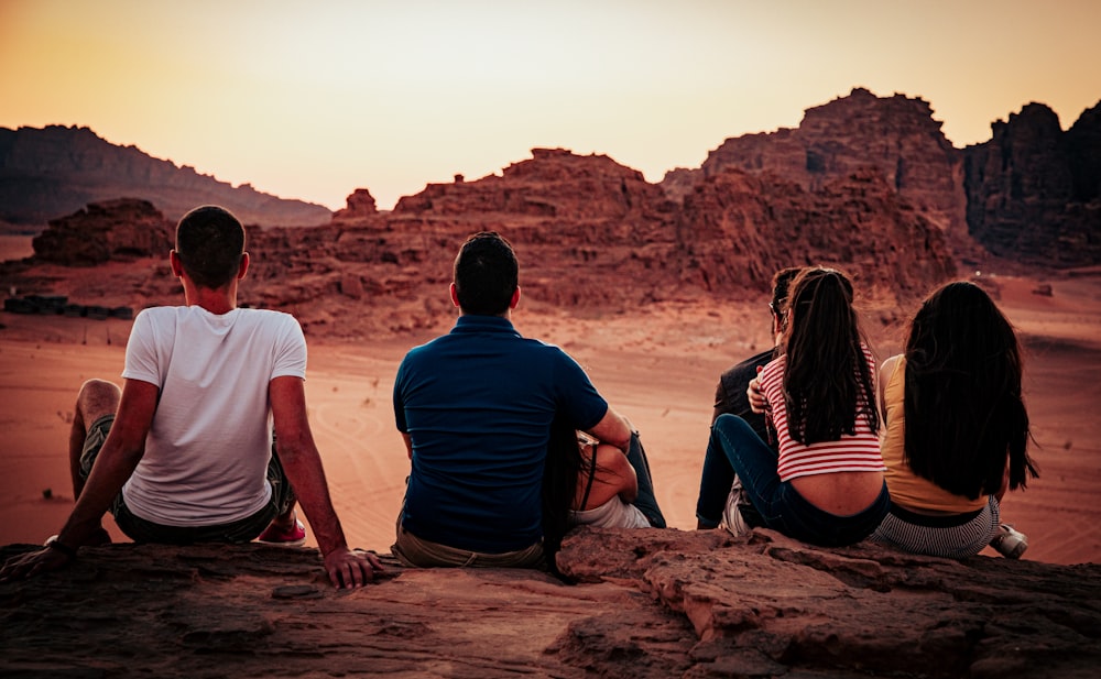 man and woman sitting on brown rock during daytime