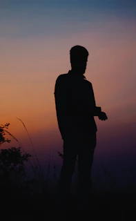 A tasteful silhouette of a woman posing against a glowing sunset, blending sensuality with natural beauty.