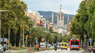 A bustling street in Ambato with buses and cyclists sharing the road during rush hour