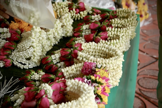 Close-up of vibrant marigold and jasmine flower garlands arranged for a traditional Haldi ceremony.
