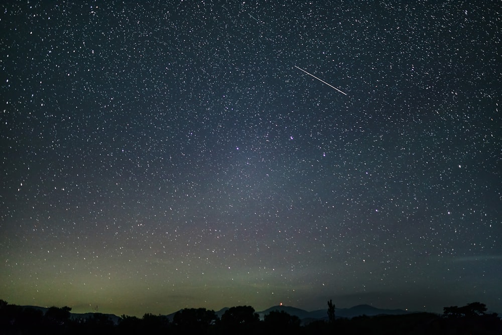 silhouette of mountain under starry night