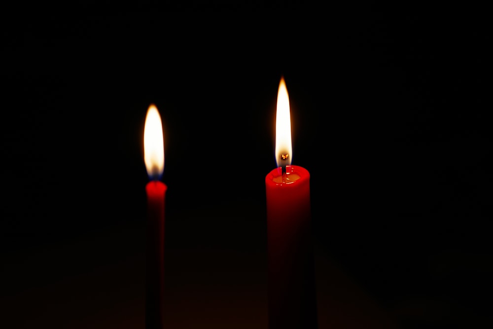 3 lighted candles on black background
