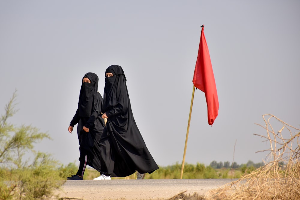 woman in black hijab holding red flag