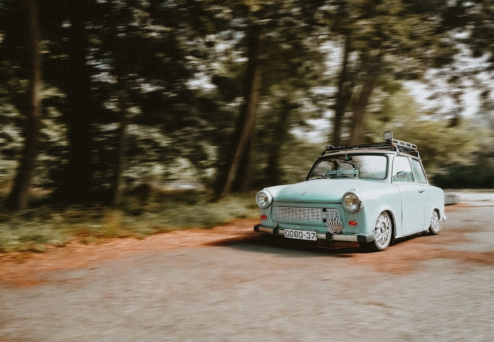 blue and white car on dirt road