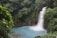 A vibrant Costa Rican waterfall surrounded by lush green jungle.