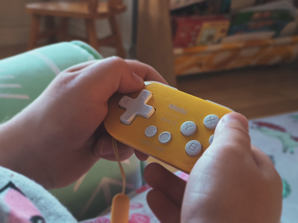 person holding yellow and blue lego toy