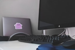 silver imac and black computer keyboard on white table