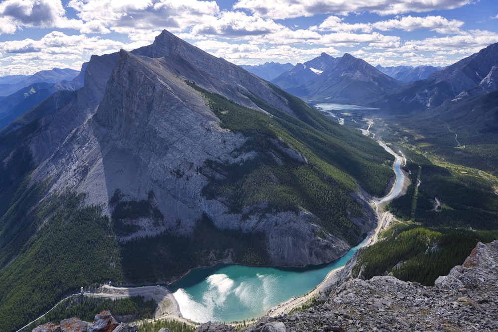 green and gray mountain beside blue lake during daytime