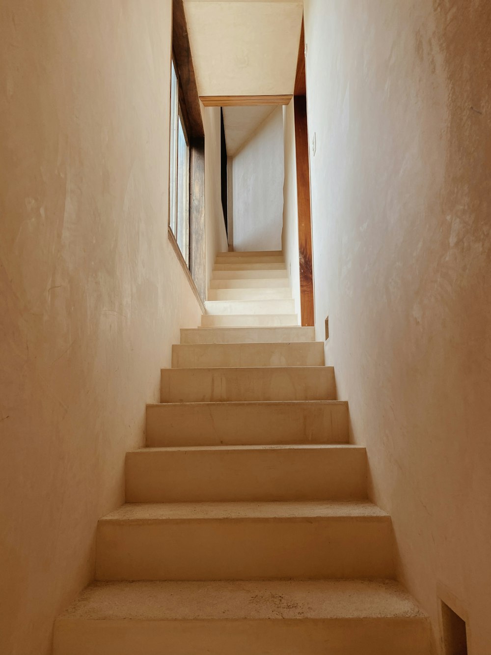 white concrete staircase with brown wooden railings