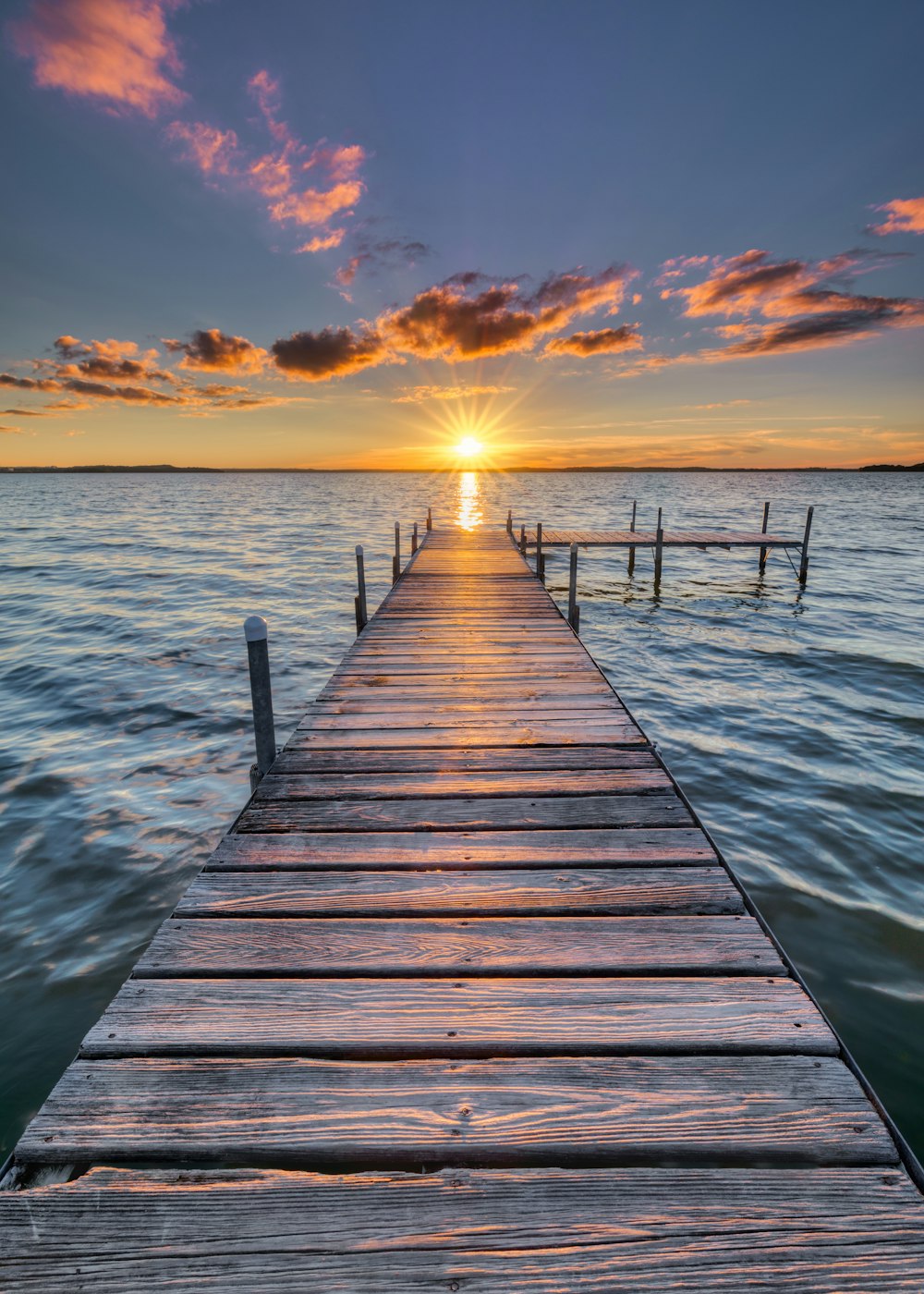 Braunes Holzdock auf See bei Sonnenuntergang