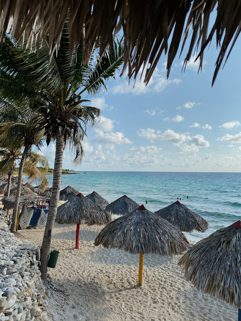 brown wooden beach lounge chair on beach during daytime