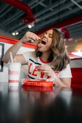 woman in white and red tank top eating