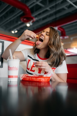 photography poses for dining,how to photograph fry-day ; woman in white and red tank top eating