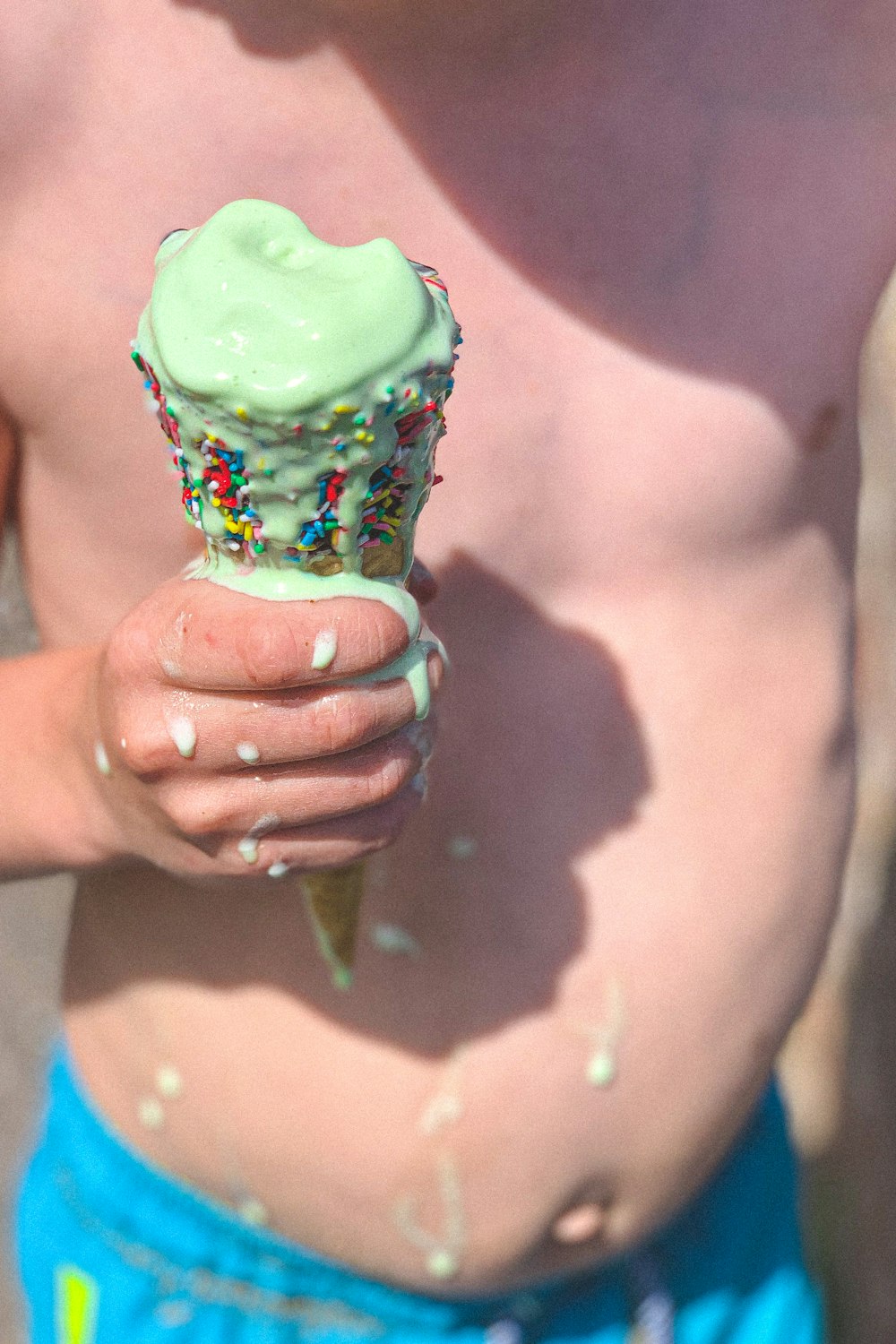 緑色のアイスクリームを持っている人