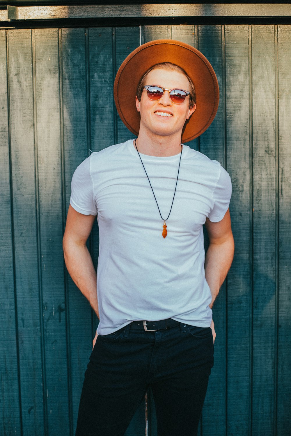 woman in white crew neck t-shirt and black pants wearing brown fedora hat