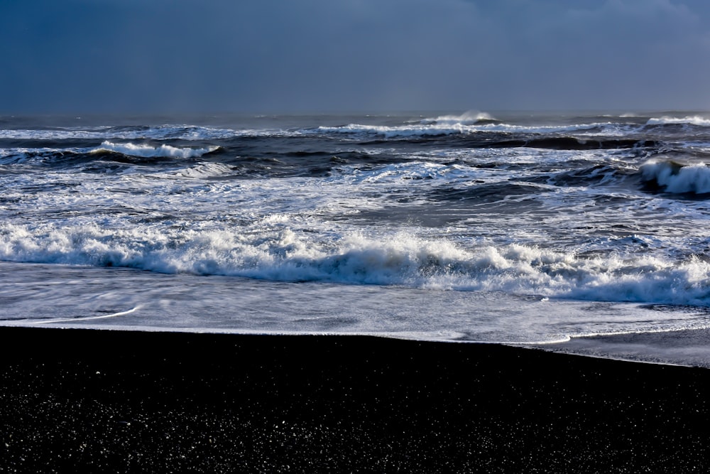 ocean waves crashing on shore during daytime