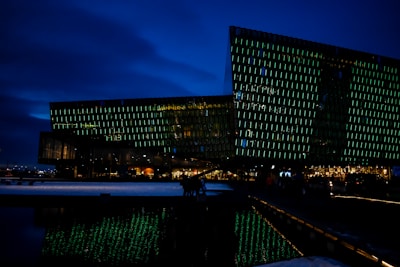 Nighttime exterior of a data center building glowing softly with deep navy and cyan lighting.