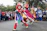 A joyful street theatre performance by La Banda de Siscaró with colorful costumes and smiling children.