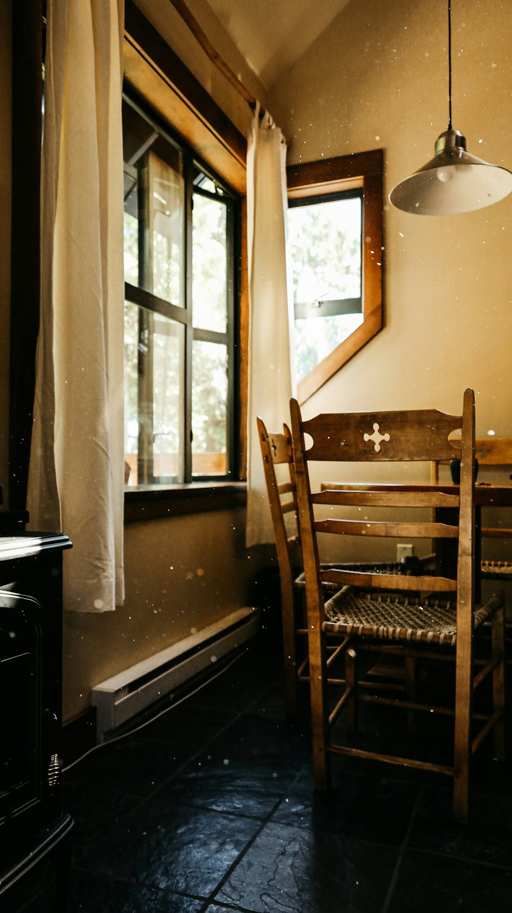cadeira de madeira marrom ao lado da janela