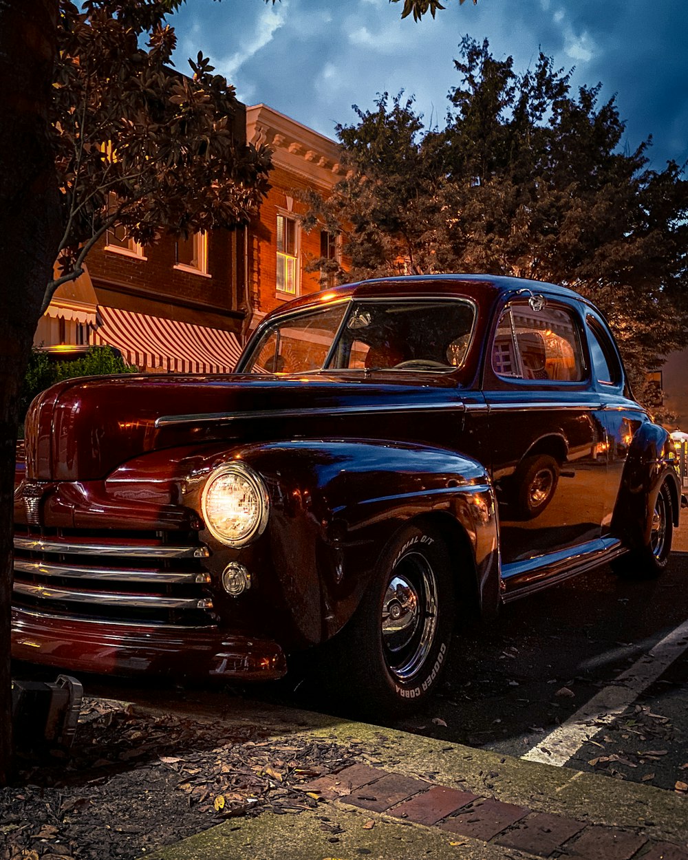 blue vintage car parked on sidewalk during daytime