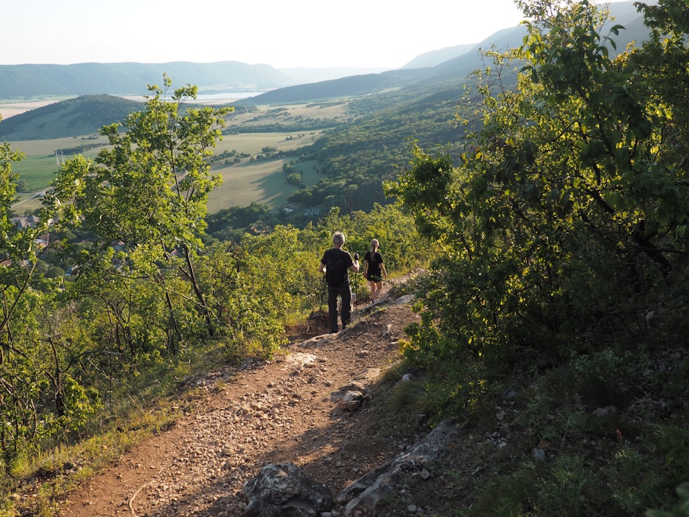 person in black jacket walking on dirt road during daytime