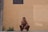 man in black shorts sitting on concrete floor