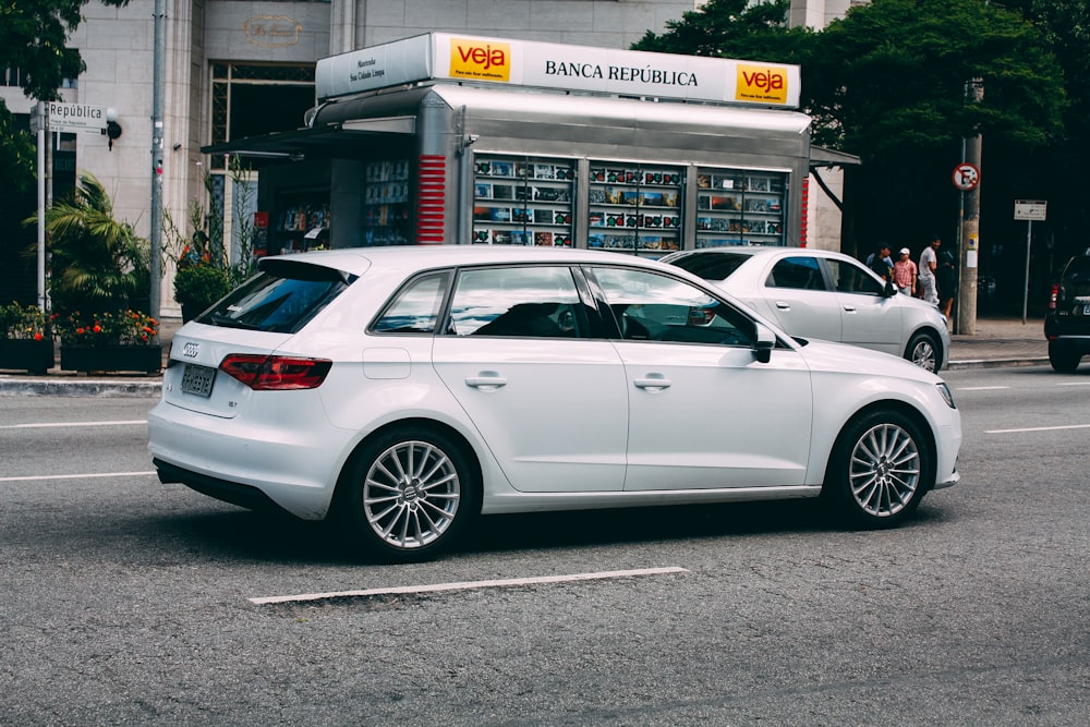 white sedan parked near white building during daytime