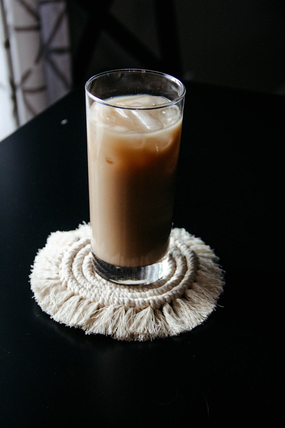 clear drinking glass with white liquid on white round coaster