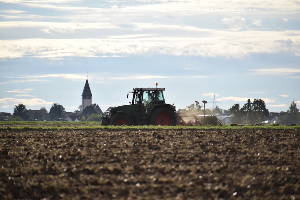 red tractor on brown field during daytime