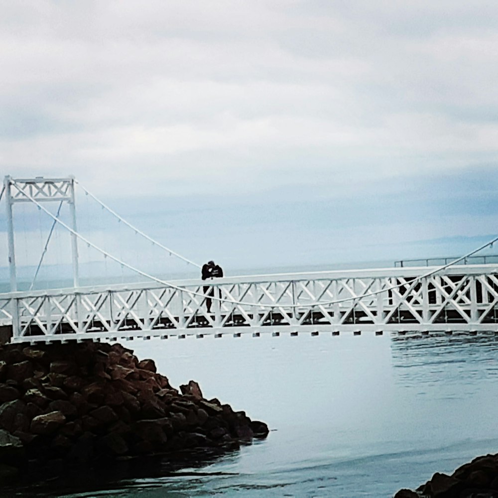 man standing on rock near bridge during daytime