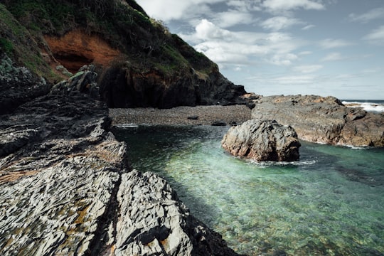 brown rock formation on body of water during daytime in Western Cape South Africa