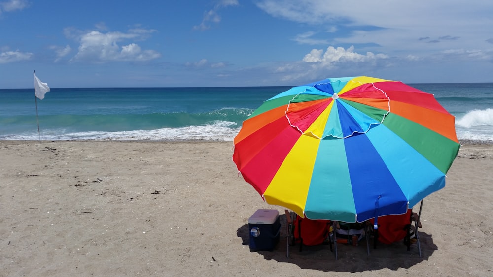 green and yellow umbrella on beach during daytime