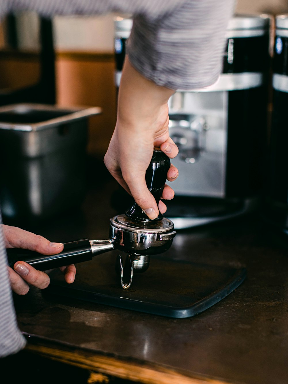 person holding black and silver coffee maker