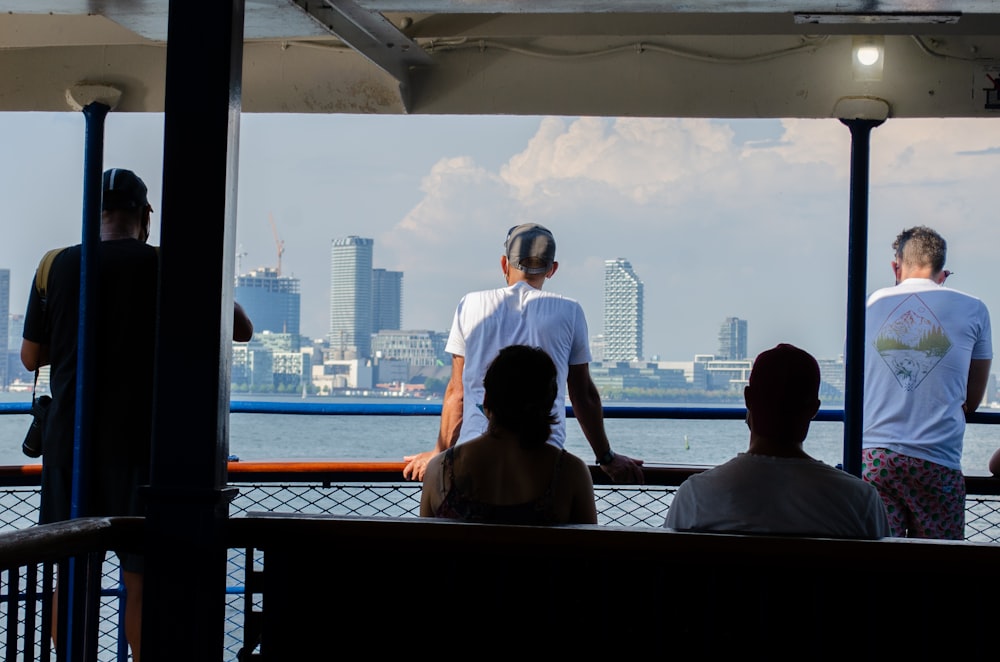 man and woman sitting on window looking at city buildings during daytime