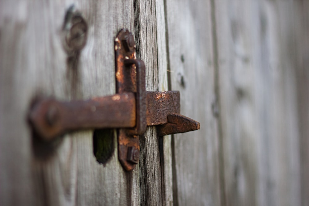 brown metal padlock on grey wooden fence