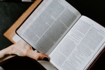 Hands of diverse people holding open books representing different religions.