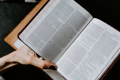 Hands of diverse people holding open books representing different religions.