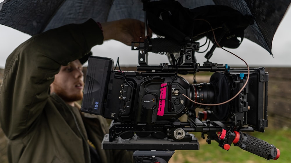 man in black jacket holding black video camera