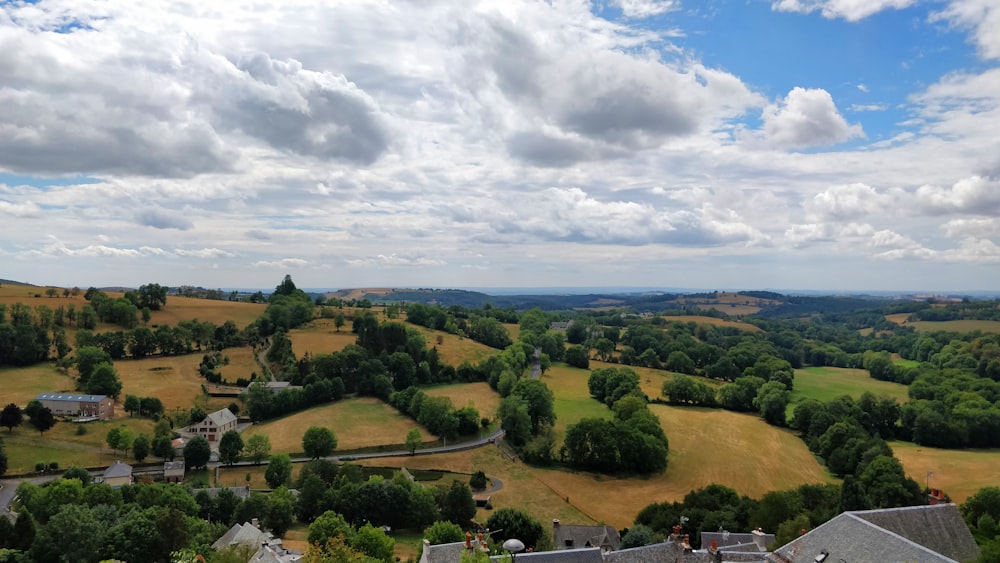 campo de hierba verde bajo nubes blancas durante el día