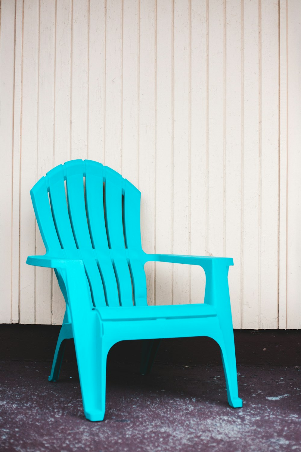 blue plastic armchair beside white wall