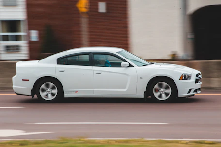 A dynamic shot of a red Dodge Charger speeding down an open highway.
