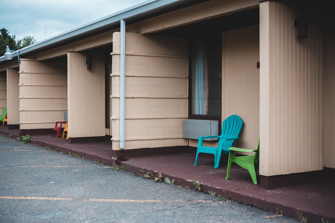 blue plastic armchair beside white wooden house