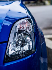 Close-up of a technician carefully restoring a foggy headlight to crystal clear condition.