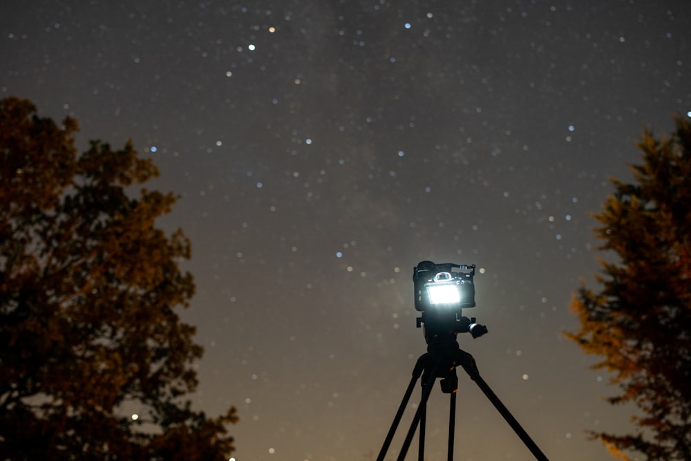 black camera with tripod during night time