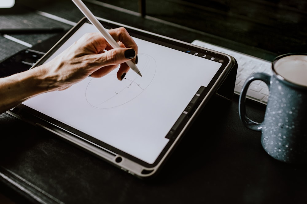 person holding white ipad with black case